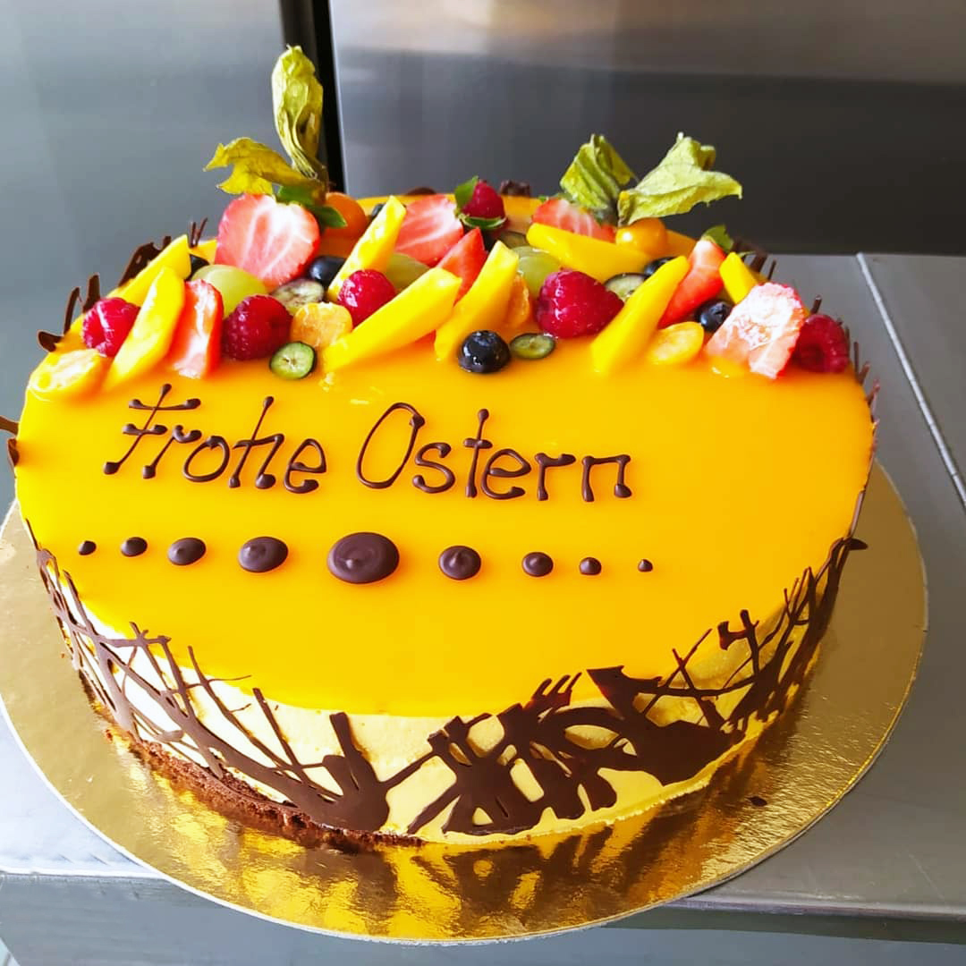 Mango-Mousse-Torte mit Schokoladenrand und Osterschriftzug