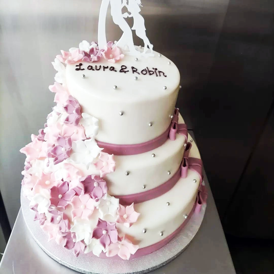 Dreistöckige Fondanttorte mit rosa Blütenkaskade