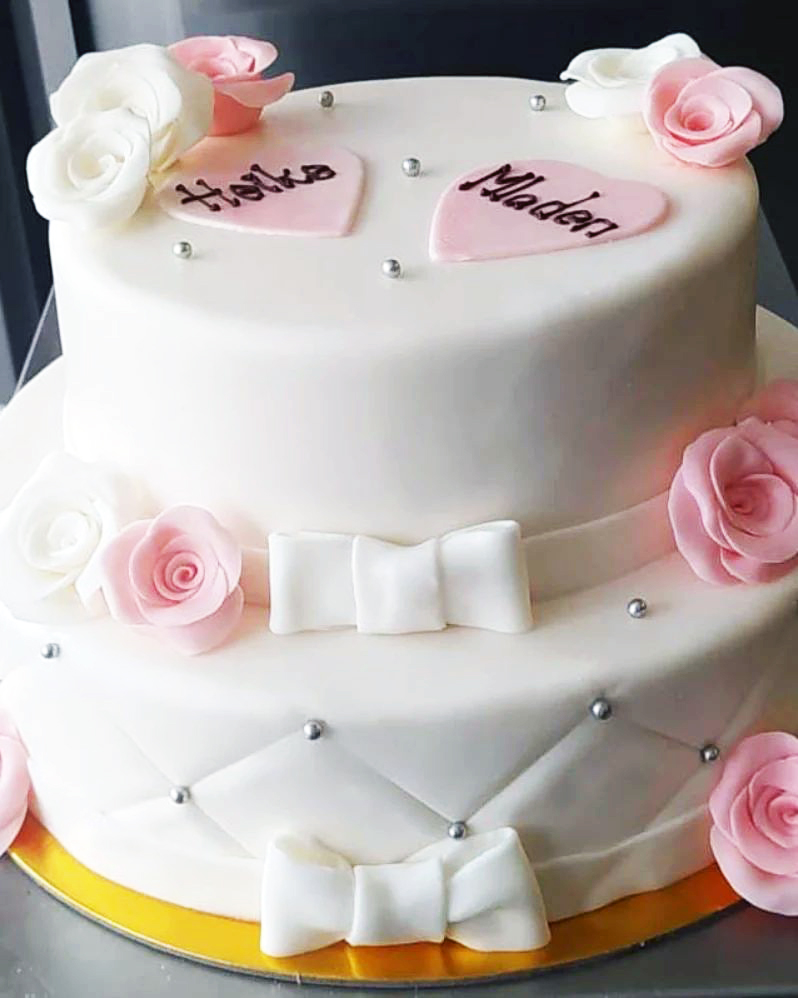 Zweistöckige Fondanttorte mit Rosen und Schleifen