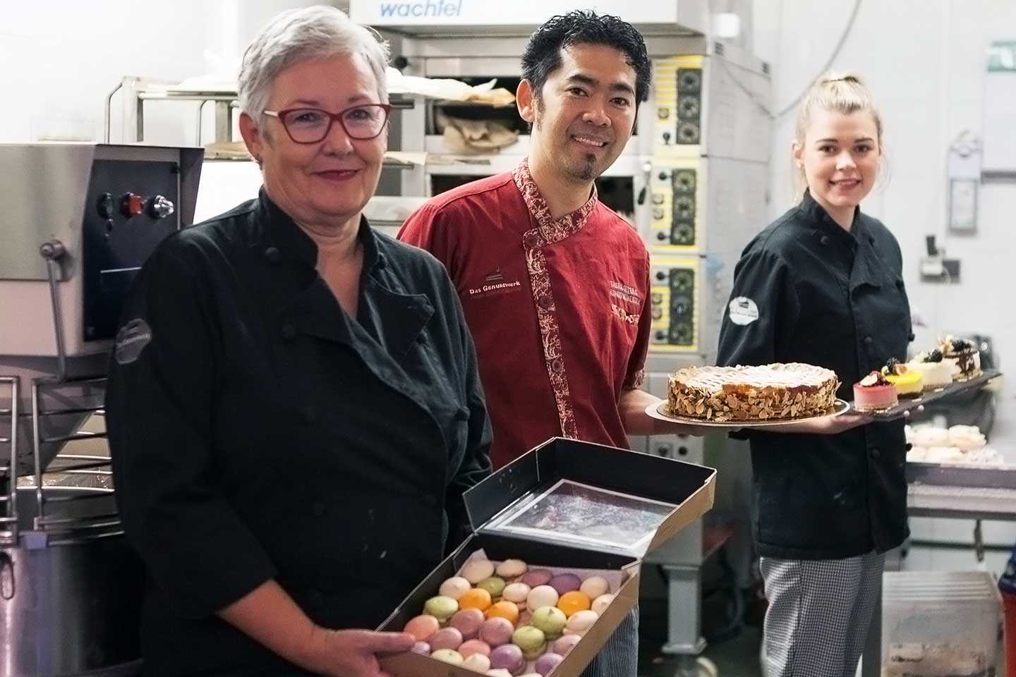 Team des Genusswerks mit Torte und Macarons