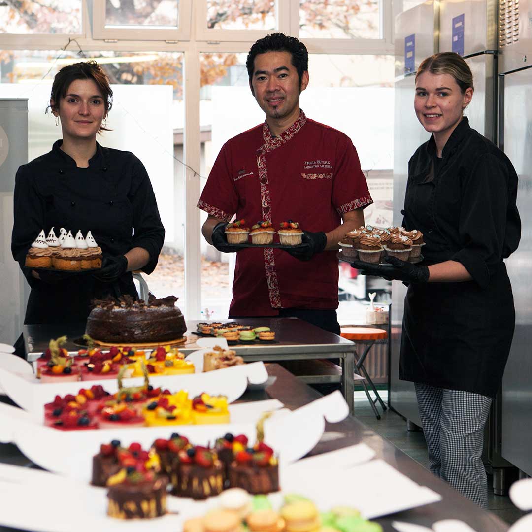 Das Team des Genusswerks mit Cupcakes in der Backstube